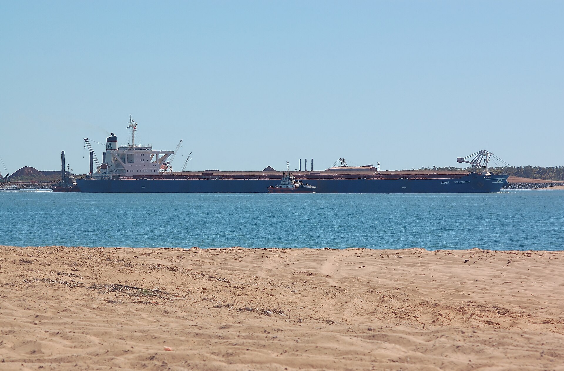 Bulk carrier departing an iron ore port under tug escort